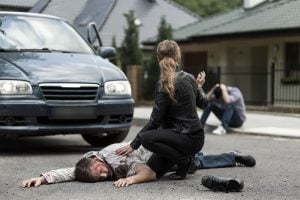 Driver hit a pedestrian Injured individual from vehicular incident lying on the pavement with visible bloodstains.