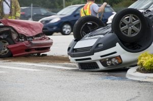 Rollover Vehicle Accident at a Busy Intersection with Emergency Responders Providing Assistance.